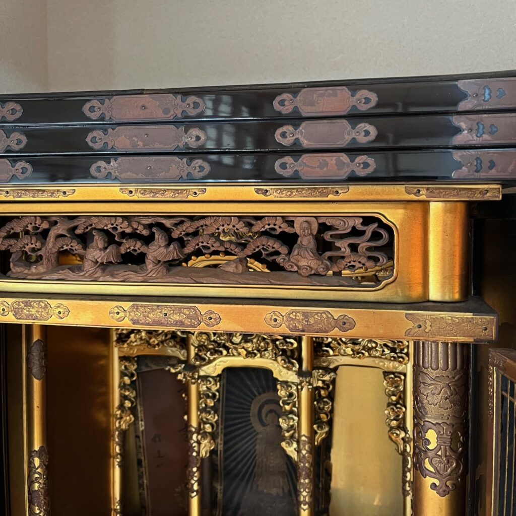 仏壇引越し・移動、運搬輸送で富山県から横浜へ移動し、磨き艶出し仕上げ後のお仏壇の上部、漆部分が顔が映り込むまでの本来の艶と輝きに蘇っている