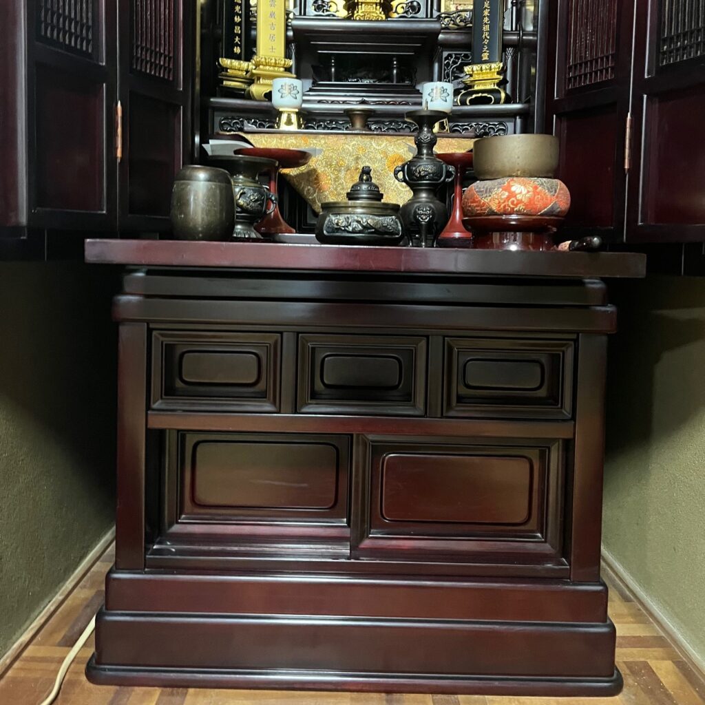 長年の煤や埃が付着して本来の艶が消えくすんでいる仏壇本体を乗せる下台部分