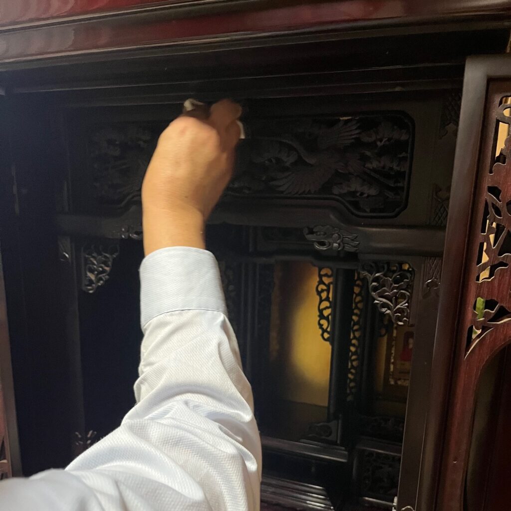 何層にも重なった煤や油分を木地や塗りを傷めないように職人が磨きながら削り落としている