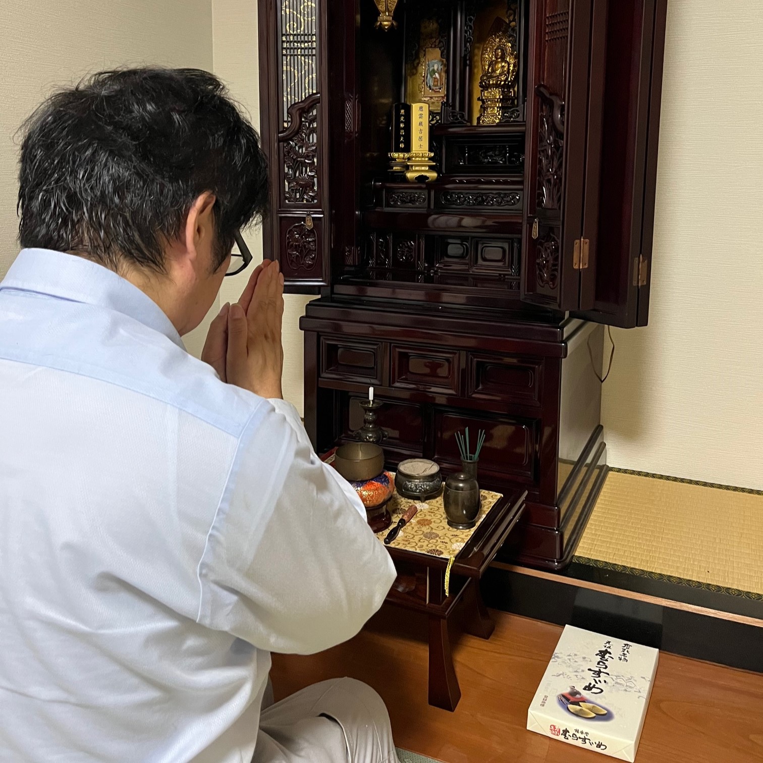 職人がお仏壇に手を合わせ感謝の思いを伝えている