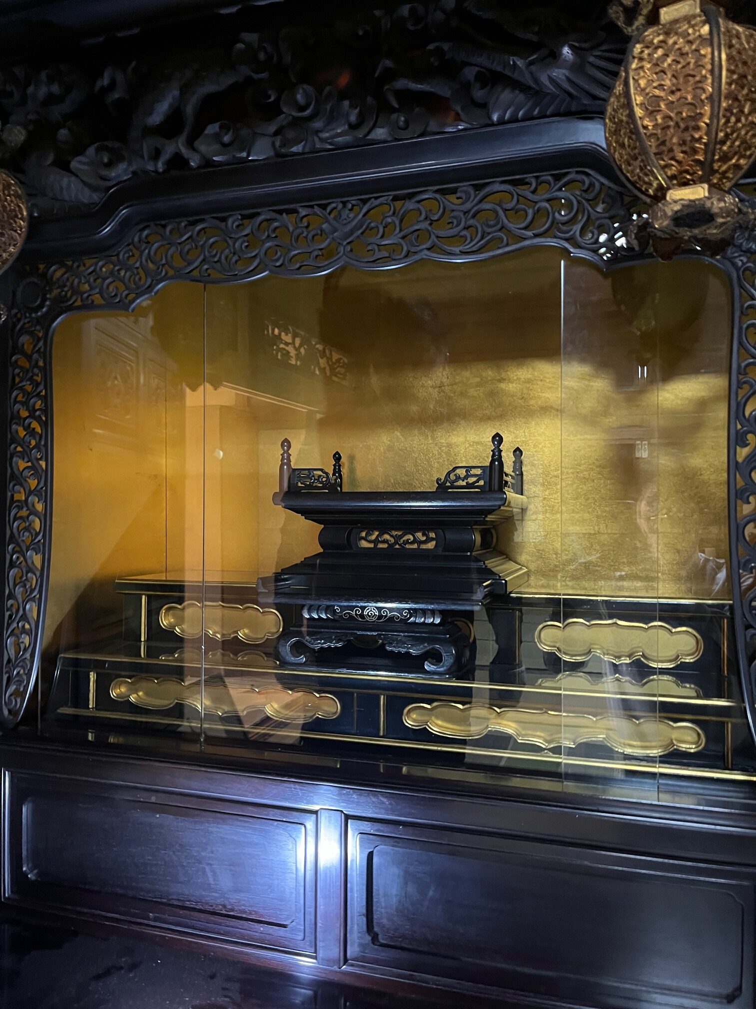 内部背板、側面部分は金箔押し、「須弥壇（しゅみだん）棚の部分」は漆塗りと金箔押しで、ガラス張りになっている