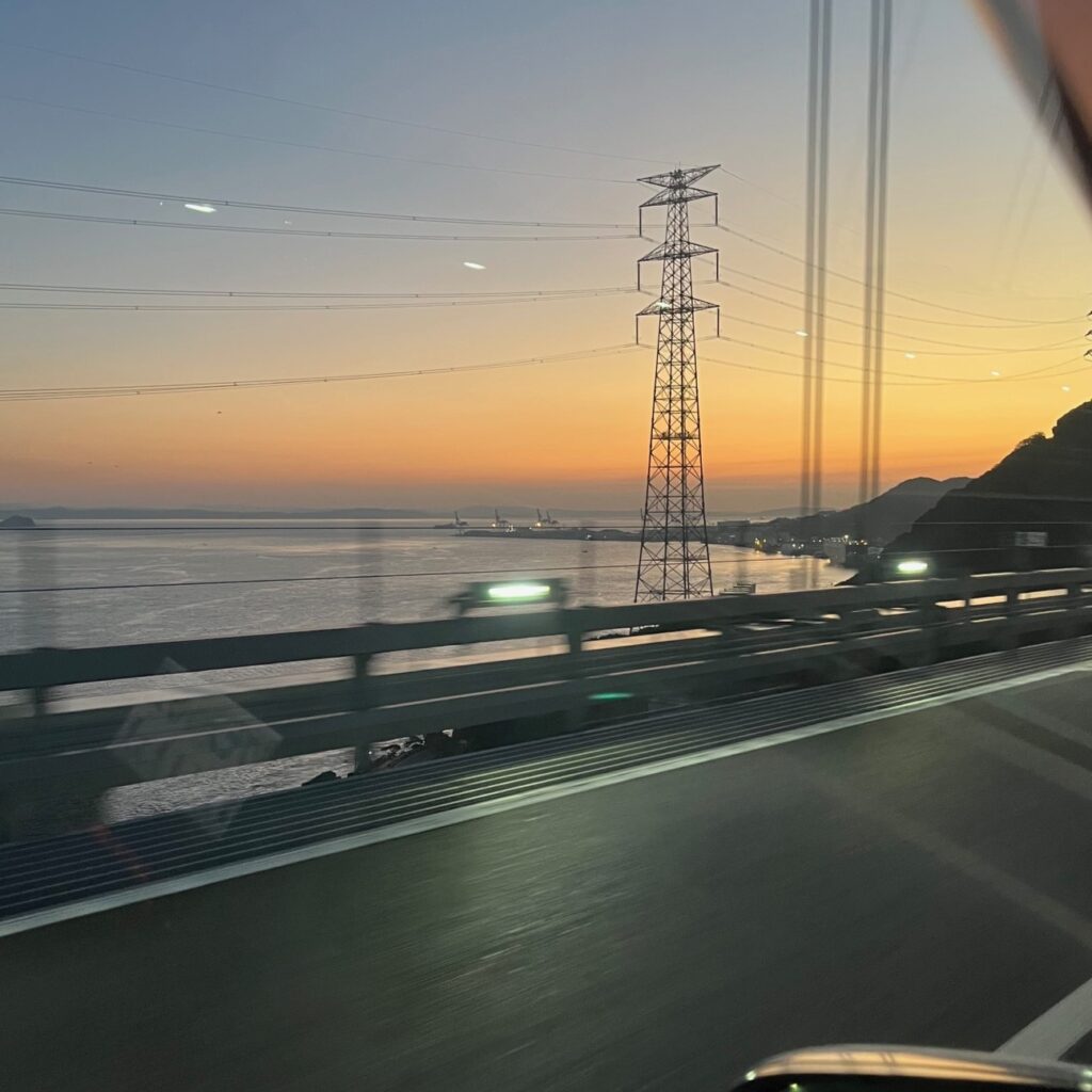 関門橋から望む差日が昇り始めて輝く空と海と街