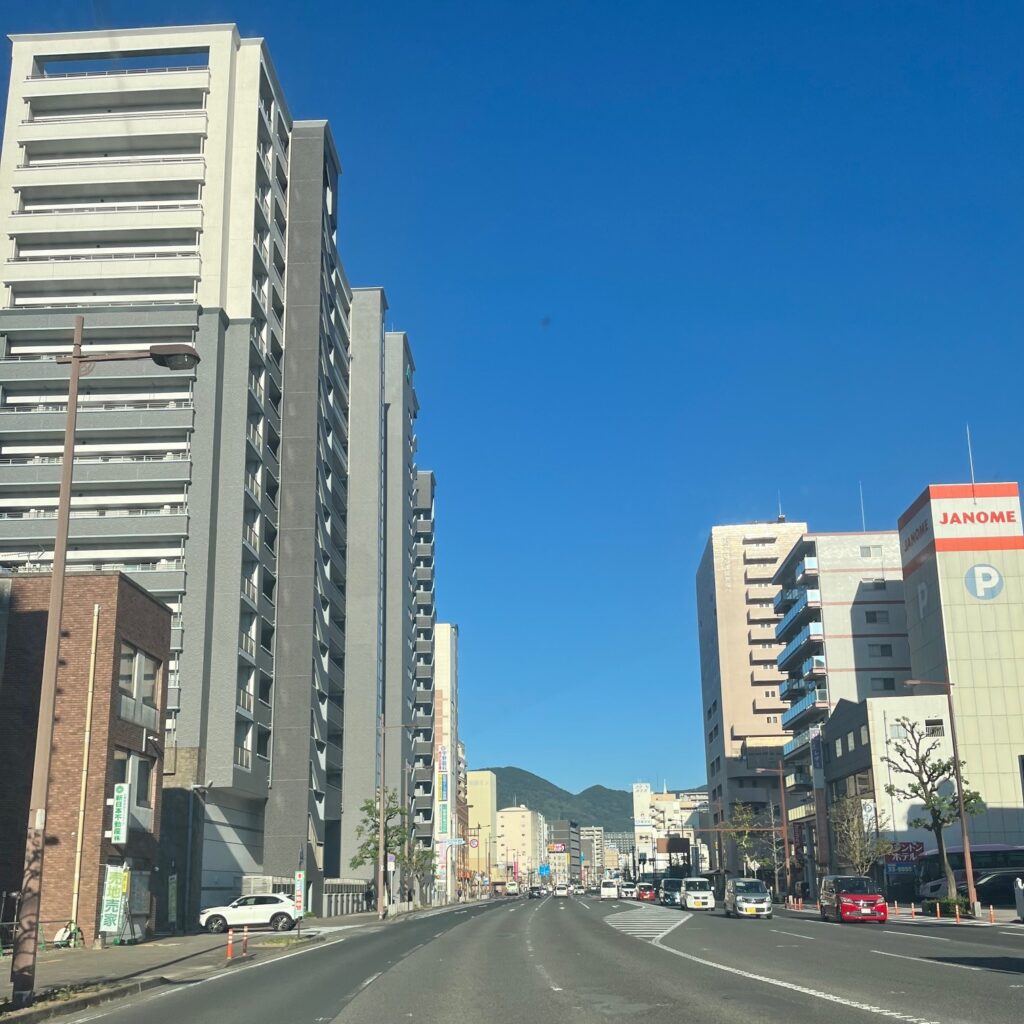 佐世保港の近くの佐世保市内の街並み、広い道路に綺麗なマンションやびるが並んでいる