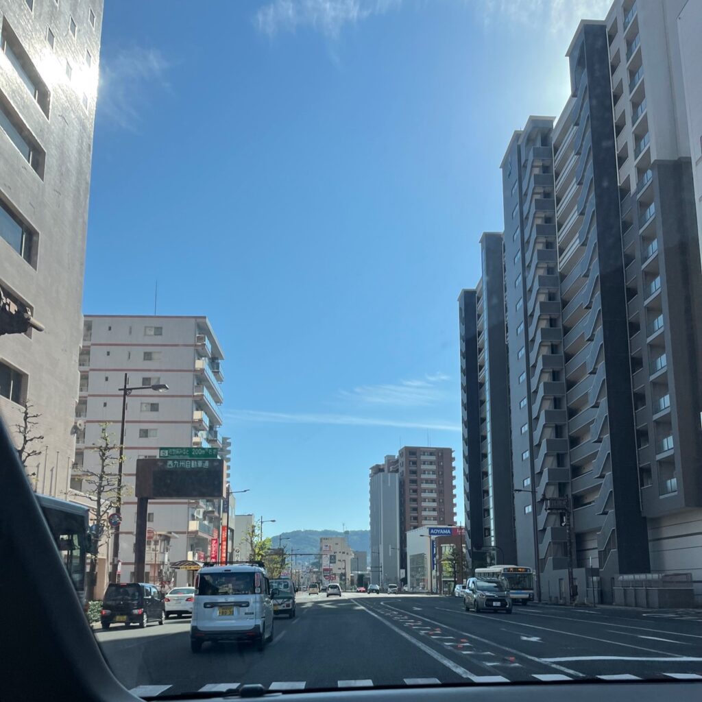 佐世保港の近くの佐世保市内の街並み、広く綺麗な道路に綺麗なマンションやビルが並んでいる