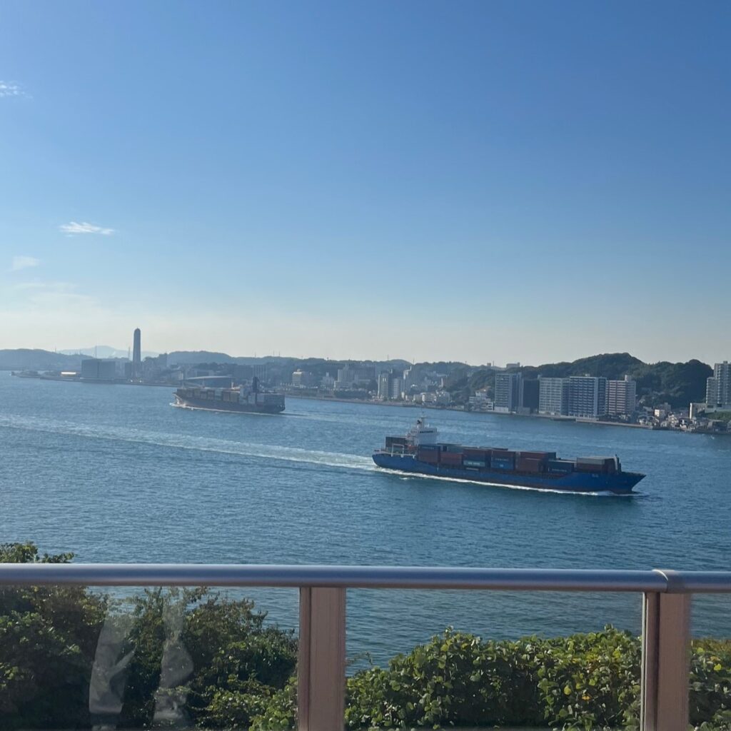 九州と本州の間の関門海峡を荷物を沢山積んだ大型タンカー船がゆっくり進んでいる