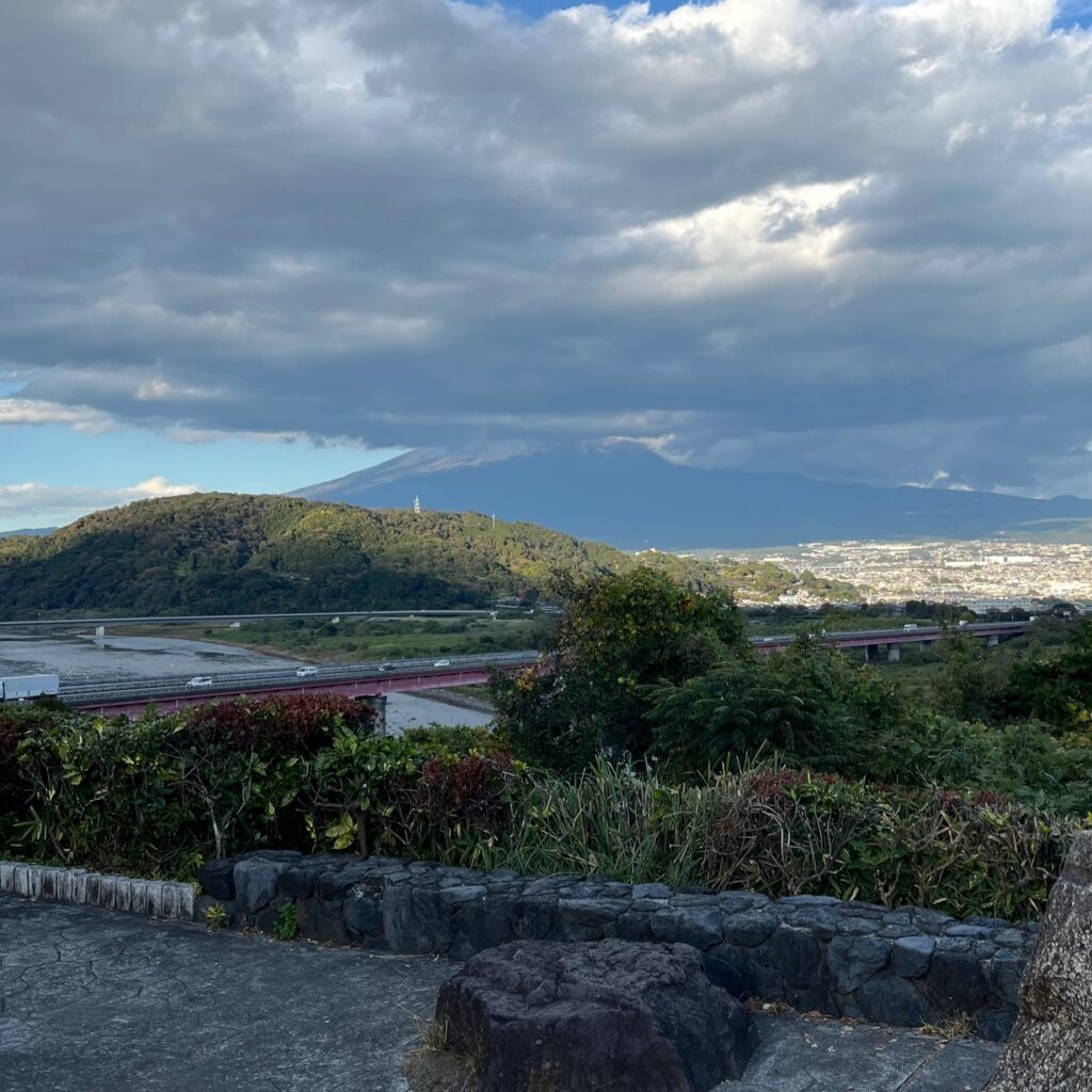 静岡県富士川サービスエリアから望む富士山、雲がかかっていて裾野だけが見える。
