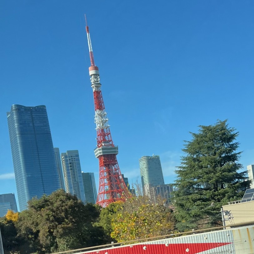 青空の下で東京タワーと超高層ビル麻布台ヒルズが並んでいる