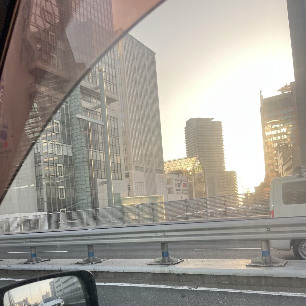高層ビルの間から太陽の光が膜しく差し込んでいる。