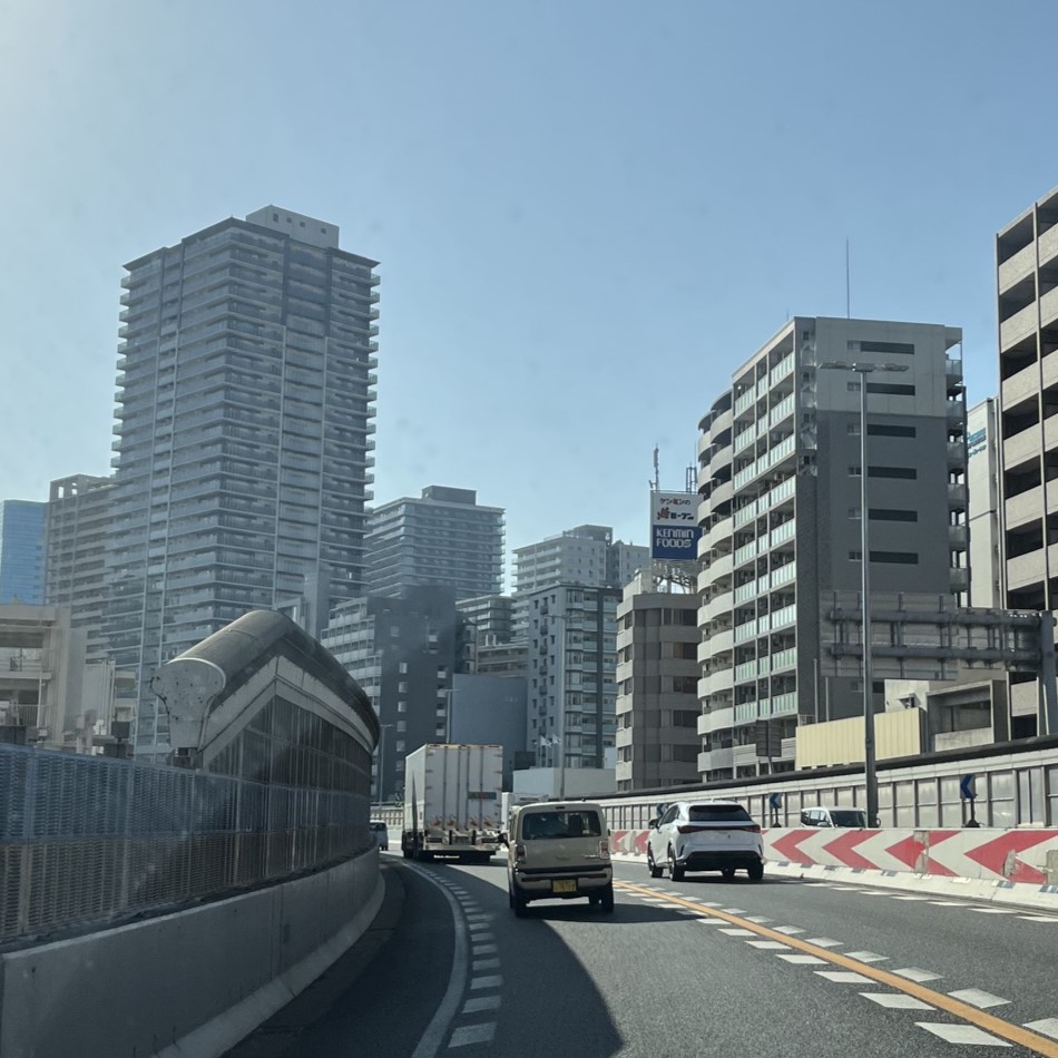 神戸中心部のビル群の間を通る阪神高速神戸線、車も多いので安全運転で走行している。