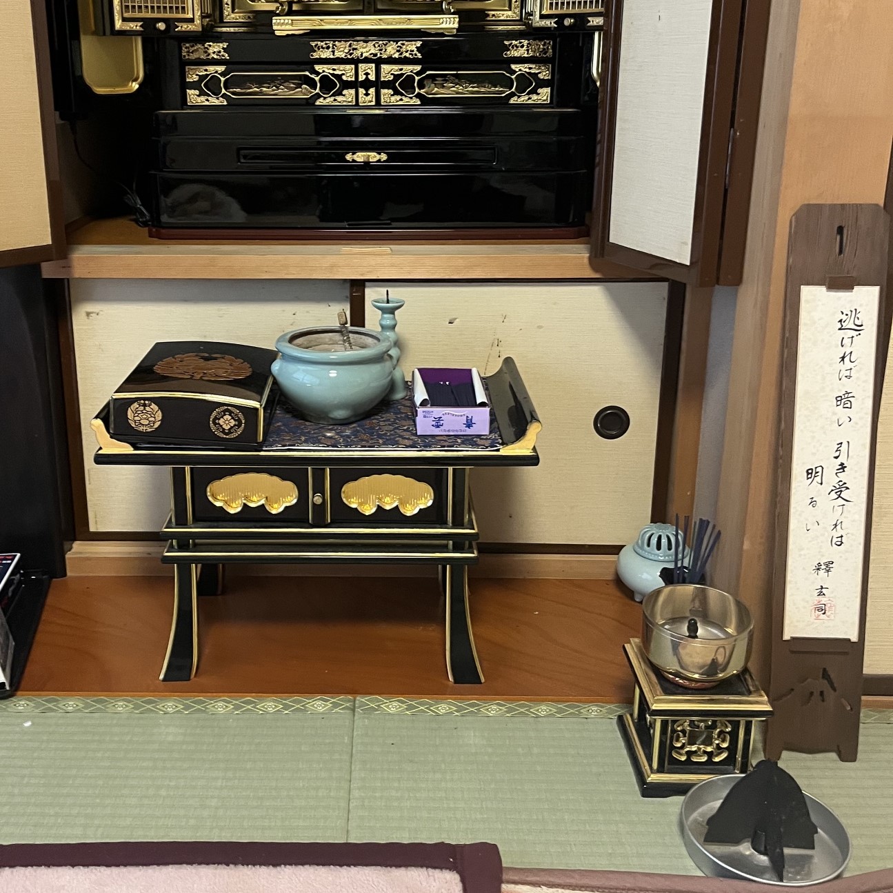 お仏壇前に置かれた黒漆に金箔が貼られたお経机。その上や横には香炉や線香、お鈴が置かれている