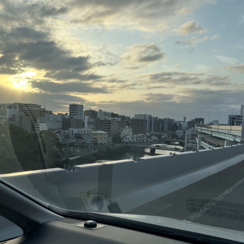 福岡都市高速から見る夕日を浴びた福岡中心部の街並み、先が見えない程広範囲でビル群が広がっている