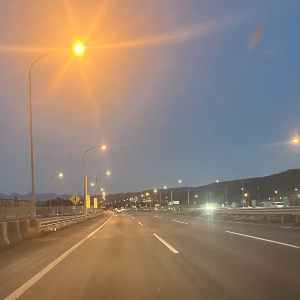 日も暮れ始め高速道路照明灯が照らされ始め夕暮れ空にオレンジの光が優しく光っている