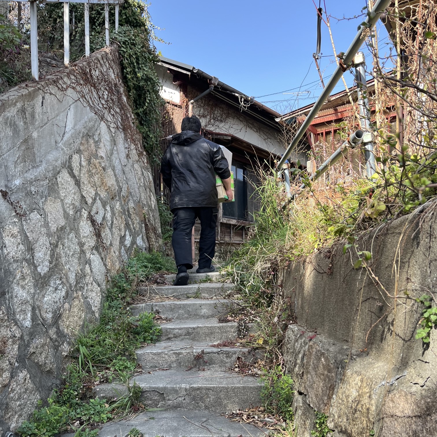 狭い階段を上がると昔ながらの木造住宅が見える